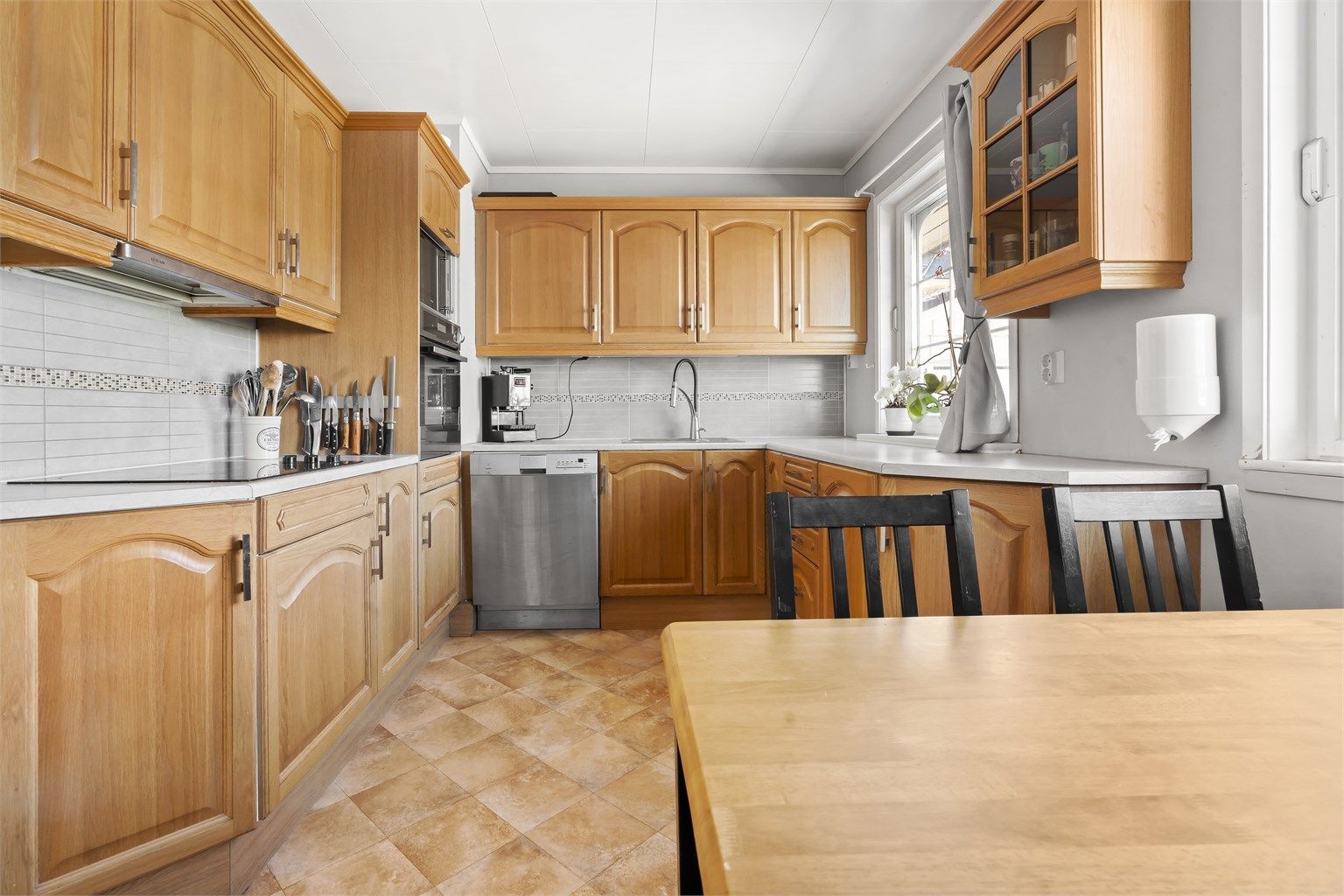 Romslig kjøkken med god oppbevaring og stor benkplass.