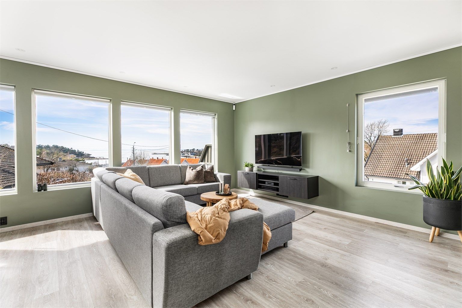 Mange store vinduer gir meget gode lysforhold i stuen og har i tillegg positiv innvirkning på romfølelsen. Overflater på gulv, vegger og himlinger er alle fra 2020.