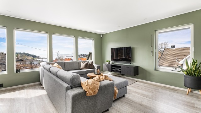 Mange store vinduer gir meget gode lysforhold i stuen og har i tillegg positiv innvirkning på romfølelsen. Overflater på gulv, vegger og himlinger er alle fra 2020.