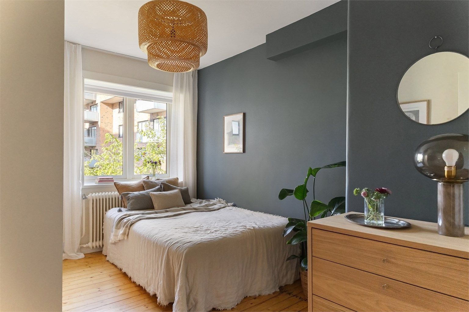 Soverommet er et lunt og fredfullt fristed med god plass til dobbeltseng og nattbord. En dyp veggfarge, mykt dagslys fra vinduet og det varme tregulvet skaper en rolig og harmonisk stemning, perfekt for gode netter og late morgener.