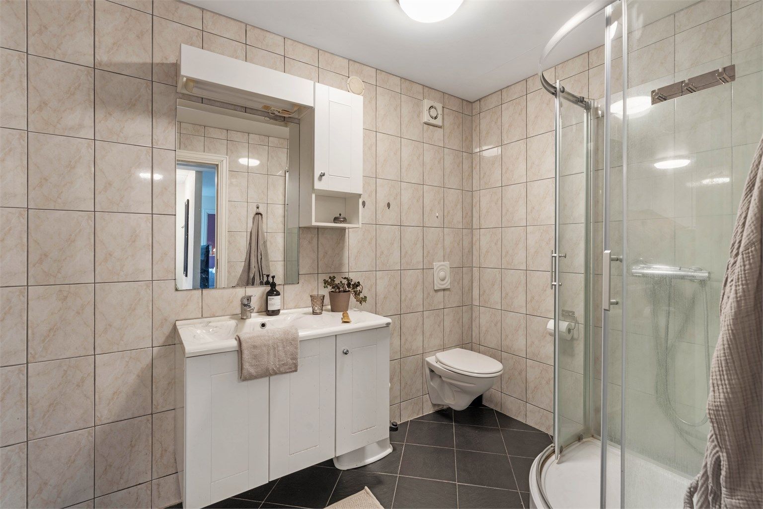 Badet i underetasjen er fra 2005 og har flislagt gulv med gulvvarme, dusjkabinett og opplegg for vaskemaskin.