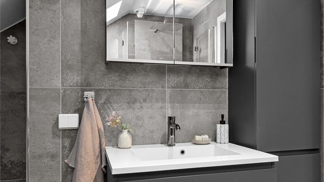 Baderomsinnredningen fra Aspen inkluderer servant med underskap, speilskap med belysning og et praktisk høyskap for ekstra oppbevaring.