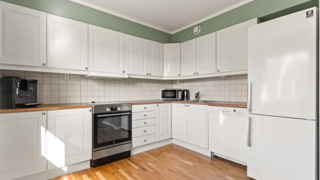 Kjøkkenet fra byggeåret har profilerte fronter, laminatbenkeplate og frittstående hvitevarer.