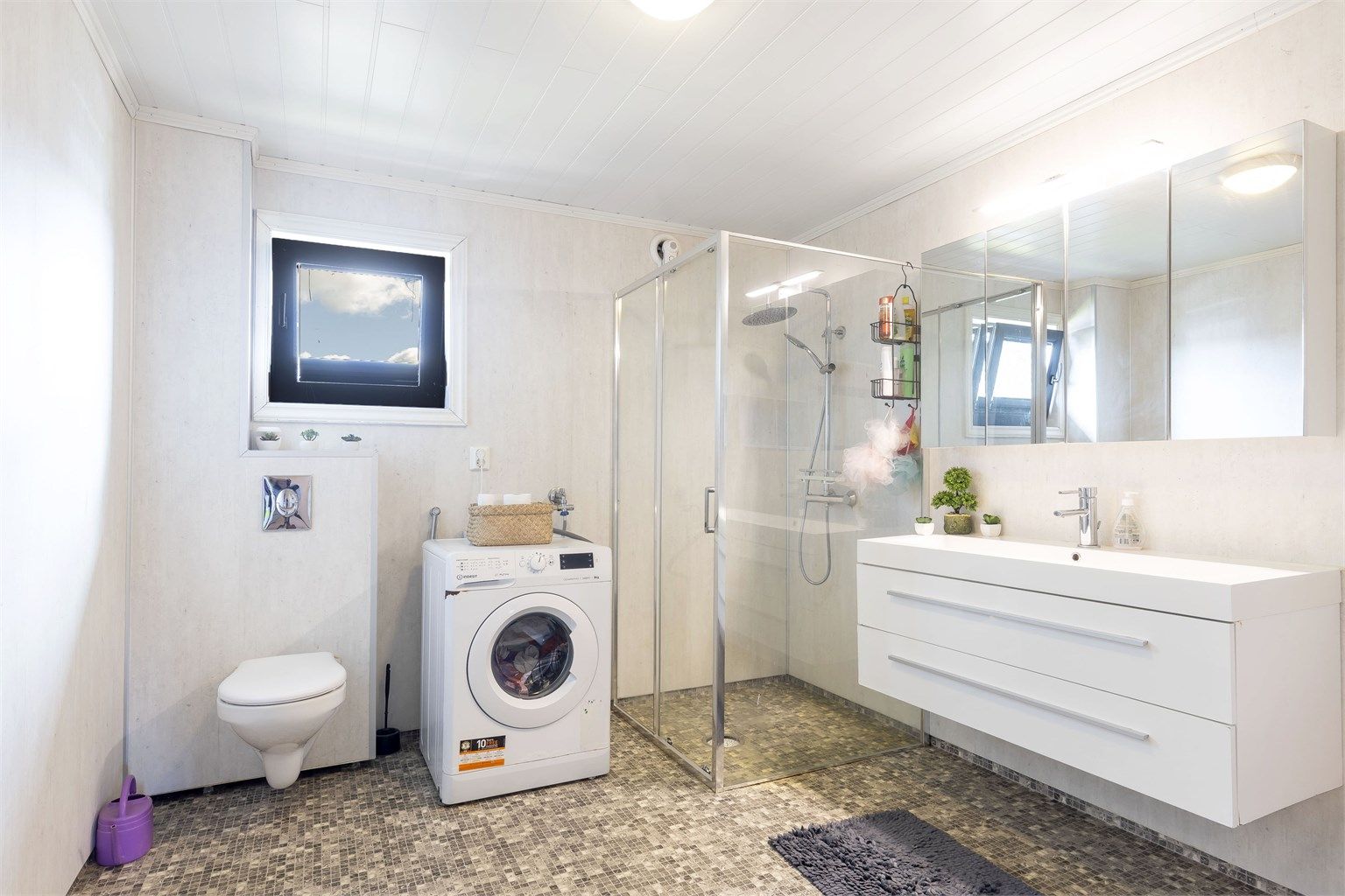 Bad i 2. etasje fra 20121/2022. Gulv med belegg. Vegger med våtromsplater, og himling med mdf panel. Innredning med slette fronter. Heldekkende servant og speilskap. Opplegg for vaskemaskin. Vegghengt toalett. Dusjhjørne med glassvegg.