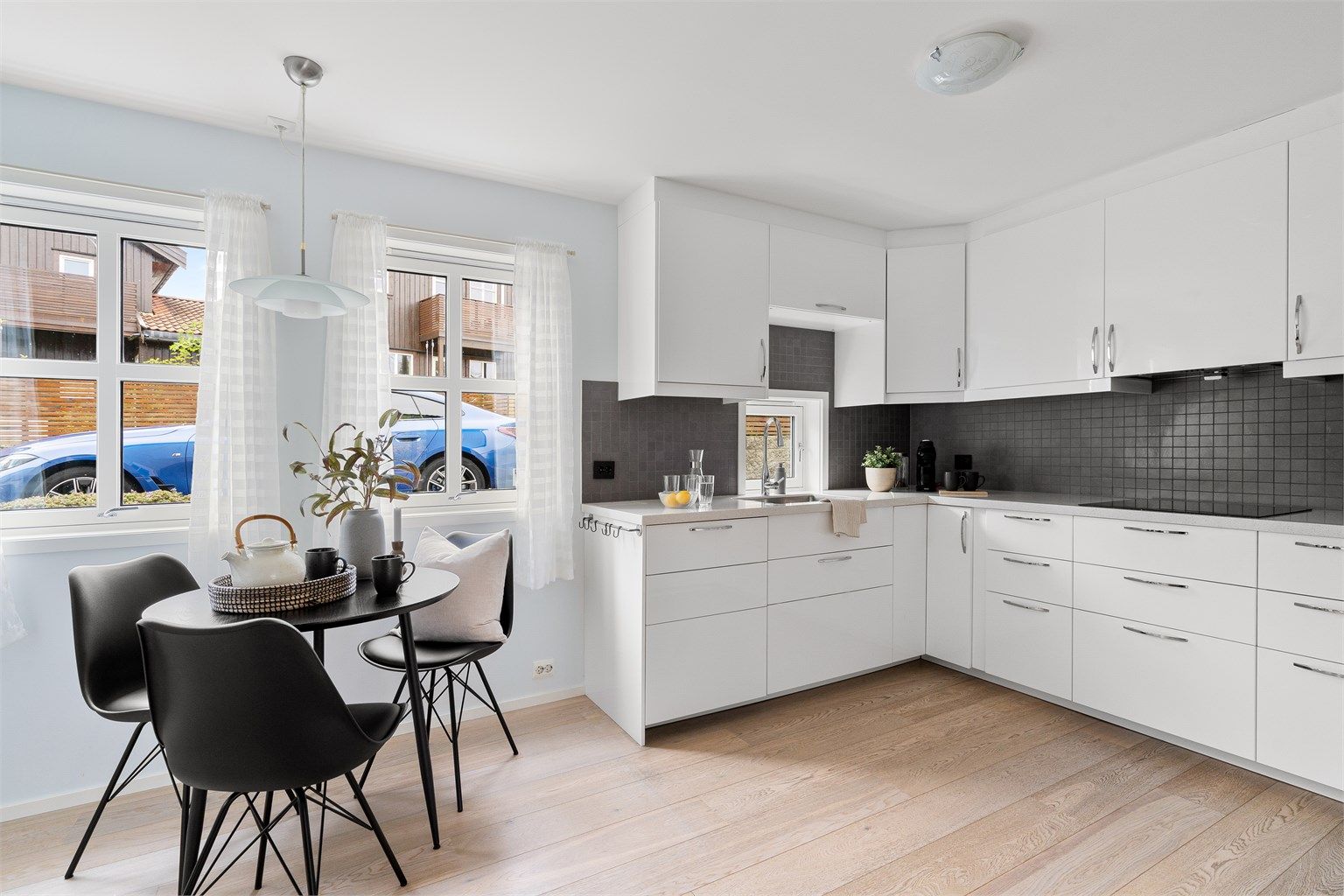 Tidløst kjøkken fra IKEA som var nytt i 2013. Innredningen er i tidløst hvitt med lys stein benkeplate. Fliser over benkeplate.  
På kjøkken er det plass til spisebord