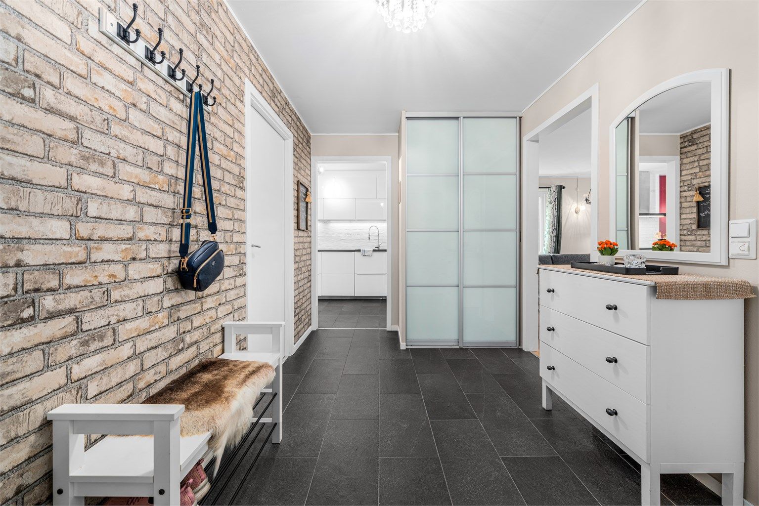 Det er flislagt gulv med varmekabler og praktisk skyvedørsgarderobe. 