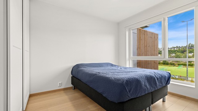 Romslig soverom med praktisk skyvedørsgarderobe for sesongenes klesbehov