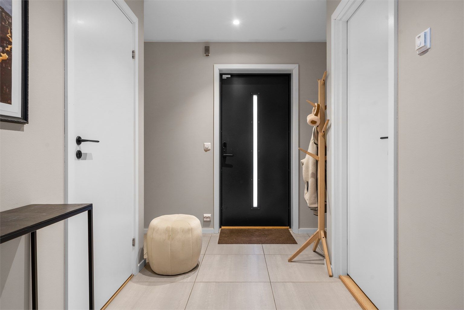 Pent flislagt entré med god plass til å henge fra seg yttertøyet