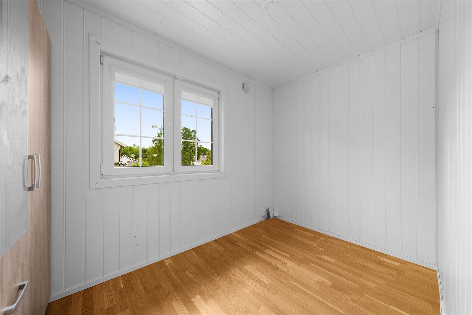 Soverommet ligger i første etasje, med panel på veggene og garderobeskap.