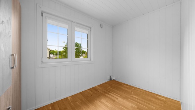 Soverommet ligger i første etasje, med panel på veggene og garderobeskap.