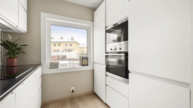 Fra kjøkkenet er det utsyn rett på fellesarealene og lekeplassen.