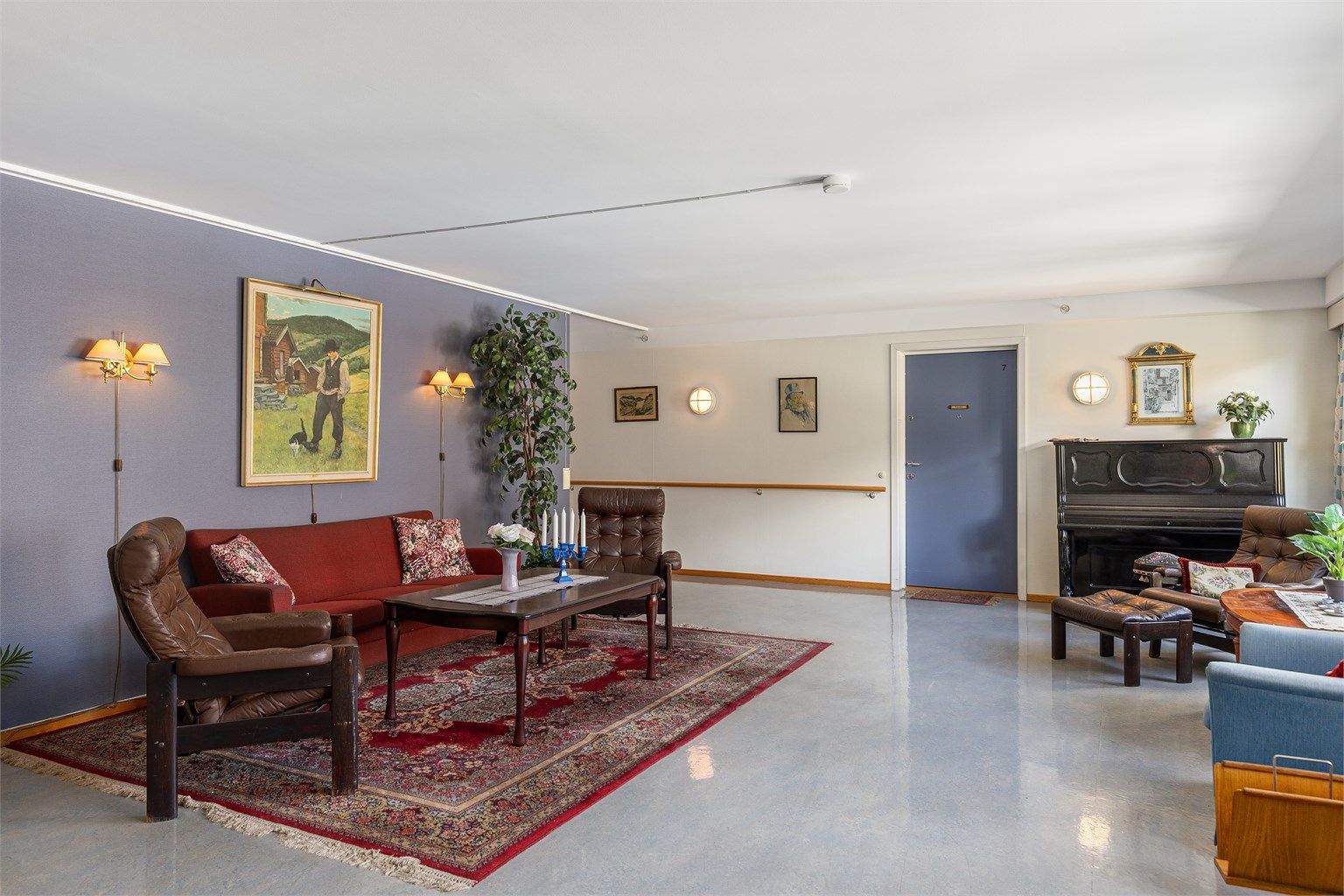 Sameiets felles oppholdsstue med sittegruppe og piano.