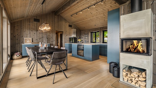 Kjøkkenet ligger i åpen løsning mot stuen, med spiseplass og peisovn som bindeledd.