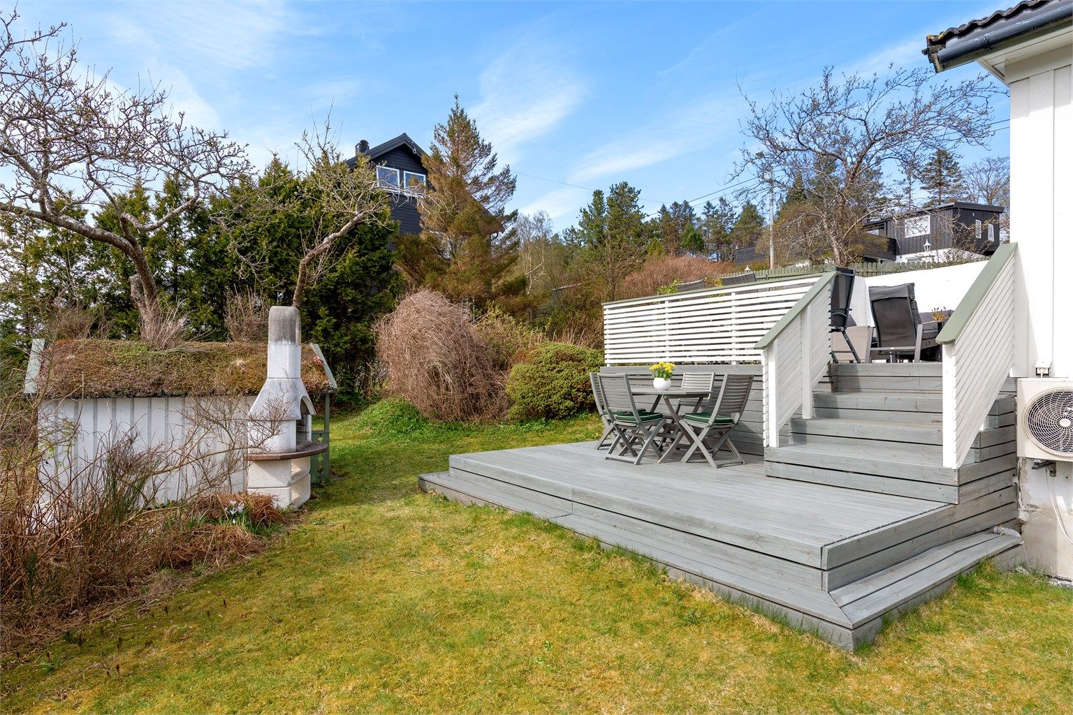 Tomten er opparbeidet med plenarealer, beplantning og terrasser i flere nivåer.