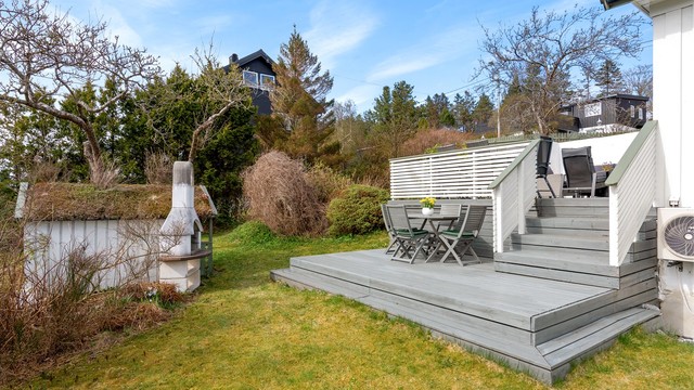 Tomten er opparbeidet med plenarealer, beplantning og terrasser i flere nivåer.