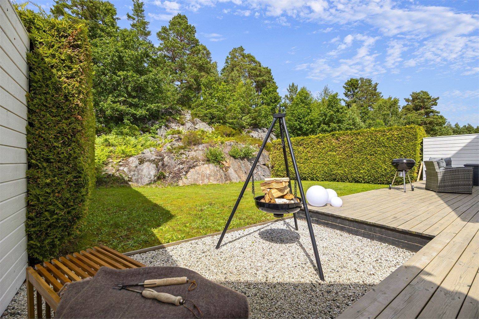 Hagen grenser mot et friområde med svaberg og natur.