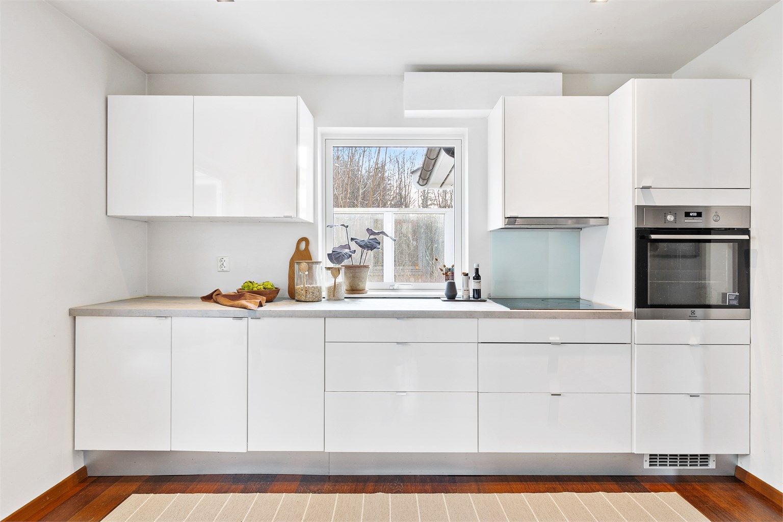 Kjøkkenet har en innredning fra 2008 med glatte fronter og integrert stekeovn og platetopp.