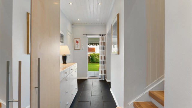 Entré med flislagt gulv, gulvvarme og downlights i taket.