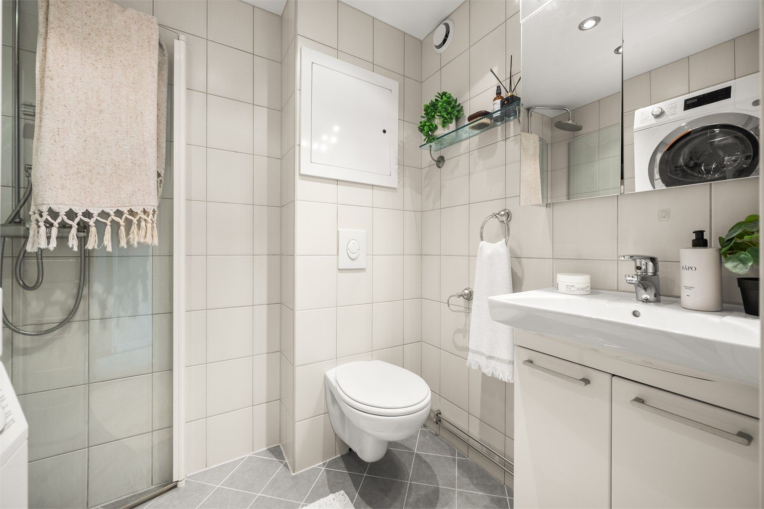 Badet er utstyrt med dusjhjørne med innfellbare dører, regnfallsdusj og rør-i-rør-system.