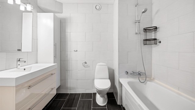 Leiligheten har to bad. Hovedbadet er helfliset og utstyrt med badekar.