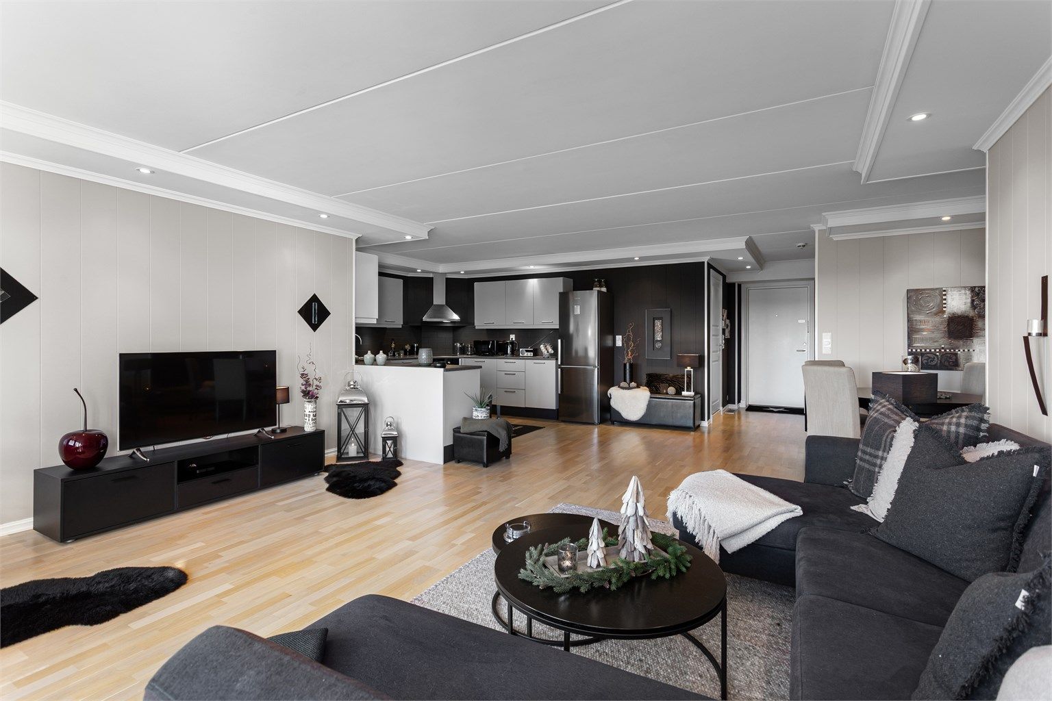 Åpen kjøkken- og stueløsning med sofaområde samt spiseplass.