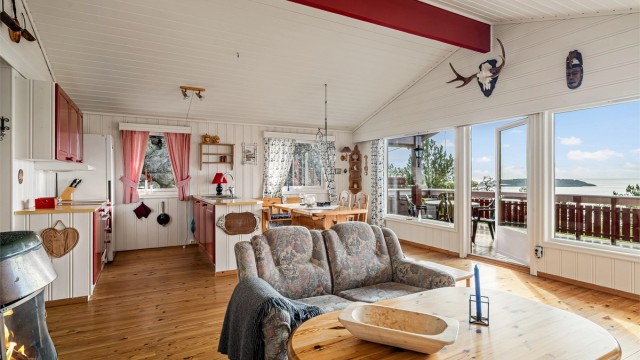 I stuen består gavlveggen mot sjøen av store vindusflater. Det gir rommet en helt spesiell atmosfære.