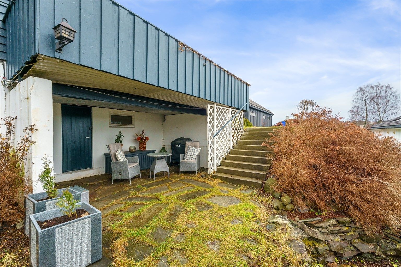 Overbygget uteplass under terrassen, med adkomst fra hagen.