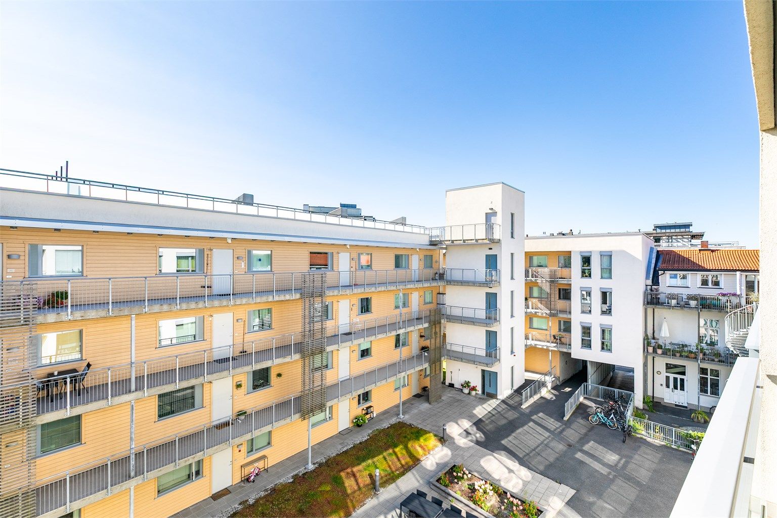 Foran verandaen er kun det avskjermede og svært fredelige gårdsrommet. Flott utsikt sees oppe i høyden på sameiets felles takaltan.