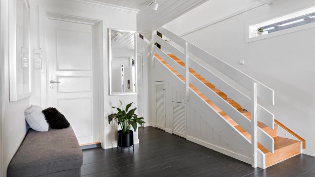 Entréen har varme i gulv og god plass. Trappen, modernisert i 1998, leder opp til hovedetasjen.