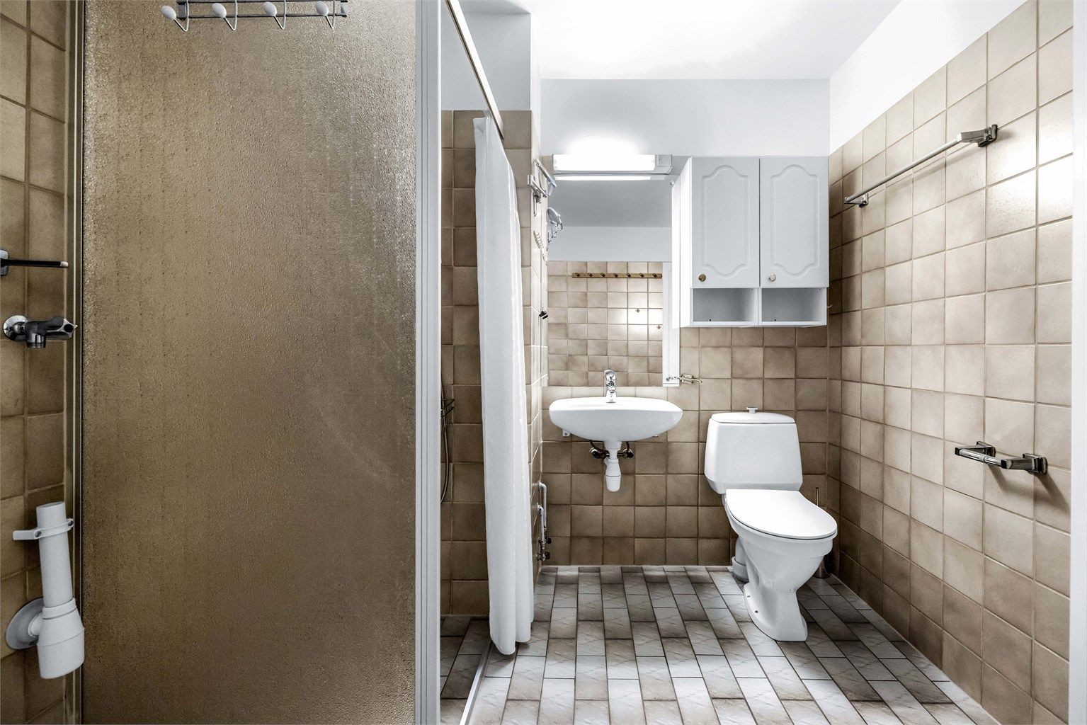 Leiligheten har et romslig flislagt bad med varmekabler.