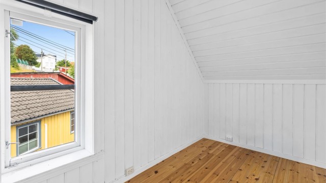 Rommet har panel på vegger og tak, og et vindu som gir godt dagslys, samt rømningsvei til veranda.
