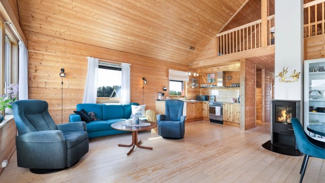 Stuen har en praktisk utforming, som bidrar til at man enkelt kan innrede med sofagruppe og spisebord i hver sin sone.