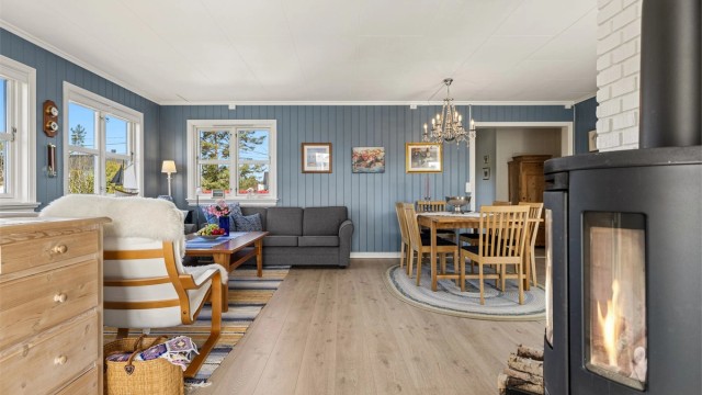Stuen har åpen forbindelse mot kjøkkenet og plass til flere sittegrupper.