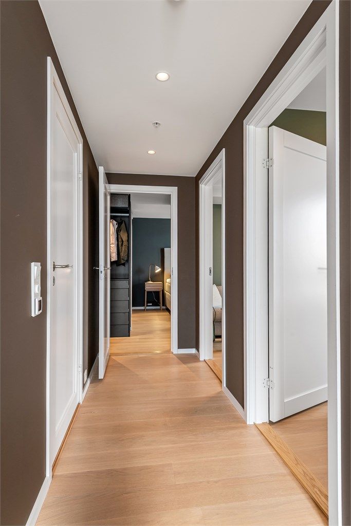 Gang med hvite profilerte innerdører og spotter i tak