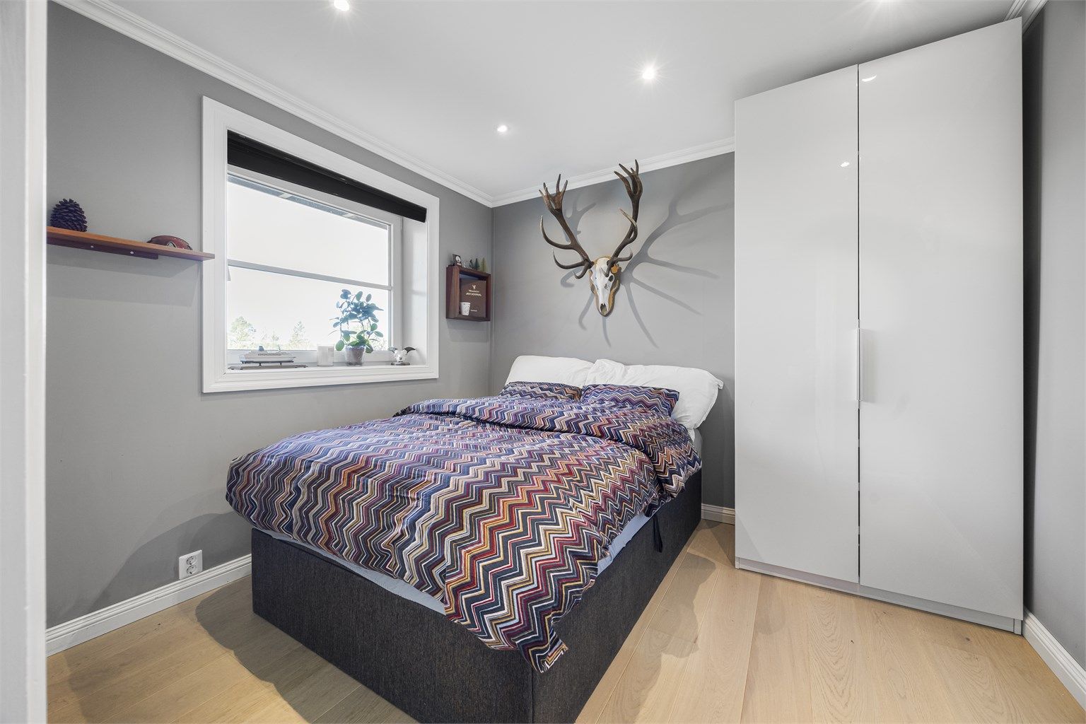 Et av soverommene i underetasjen, med plass til seng og garderobeskap.