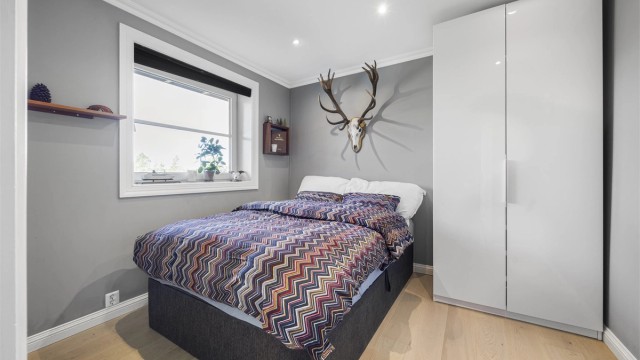 Et av soverommene i underetasjen, med plass til seng og garderobeskap.