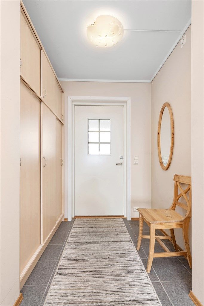 Entrédør med sikkerhetslås og glassfelt. Sikringsskapet er plassert her i gangen.