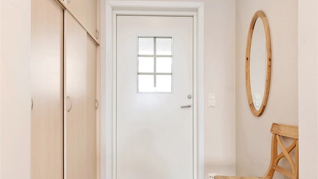Entrédør med sikkerhetslås og glassfelt. Sikringsskapet er plassert her i gangen.