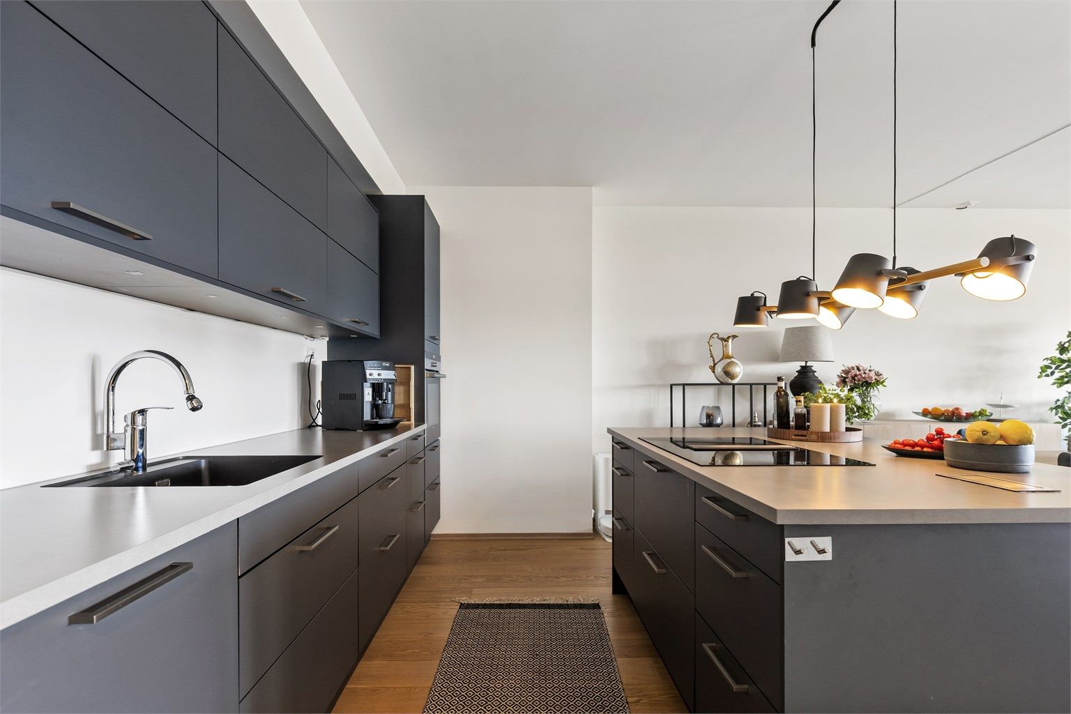 Kjøkkenøya fungerer som en naturlig romdeler og gir ekstra arbeids- og oppbevaringsplass.