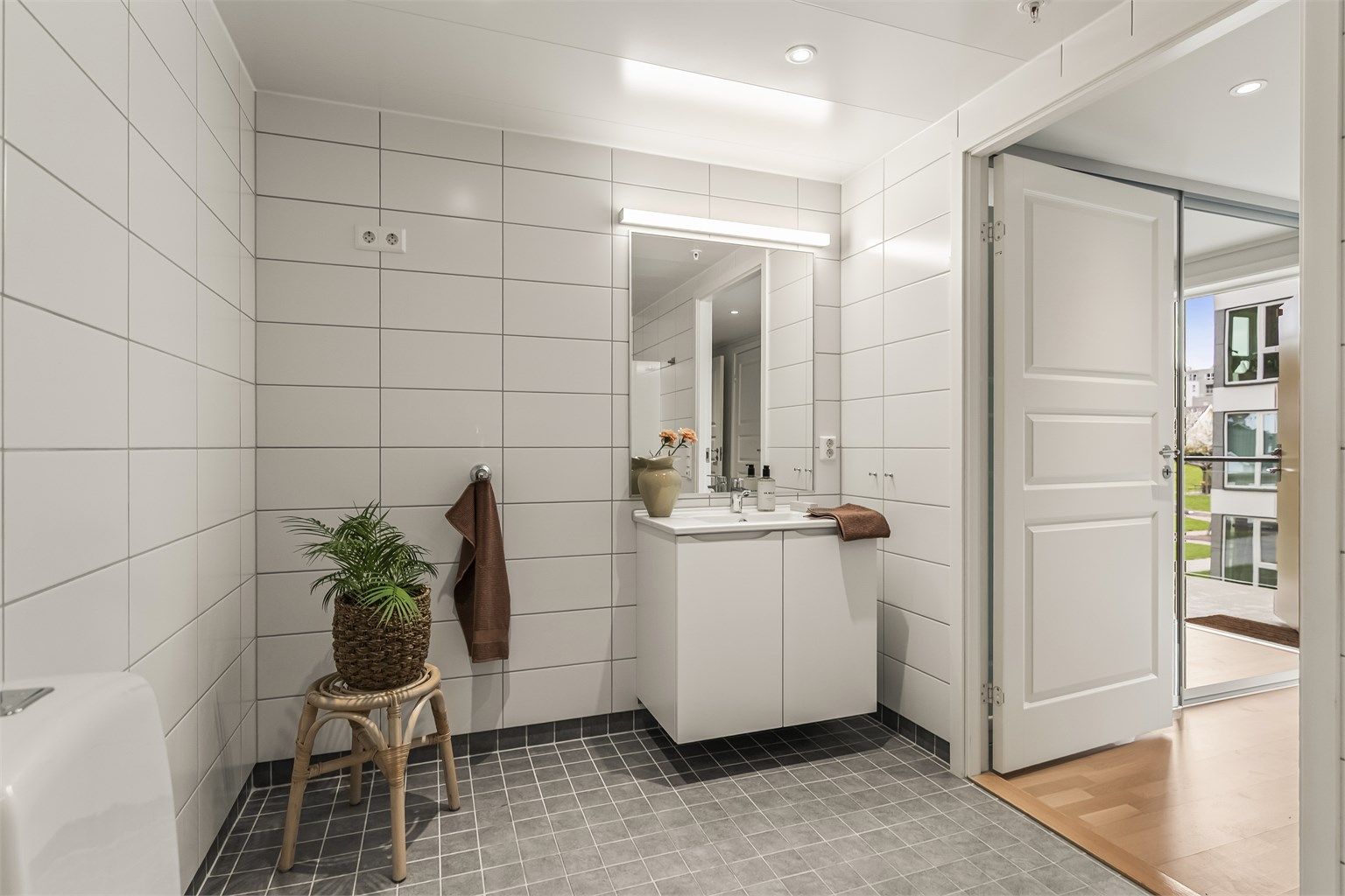 Baderomsinnredningen har slette fronter og heldekkende servant. Det er også opplegg for vaskemaskin.