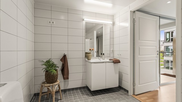 Baderomsinnredningen har slette fronter og heldekkende servant. Det er også opplegg for vaskemaskin.