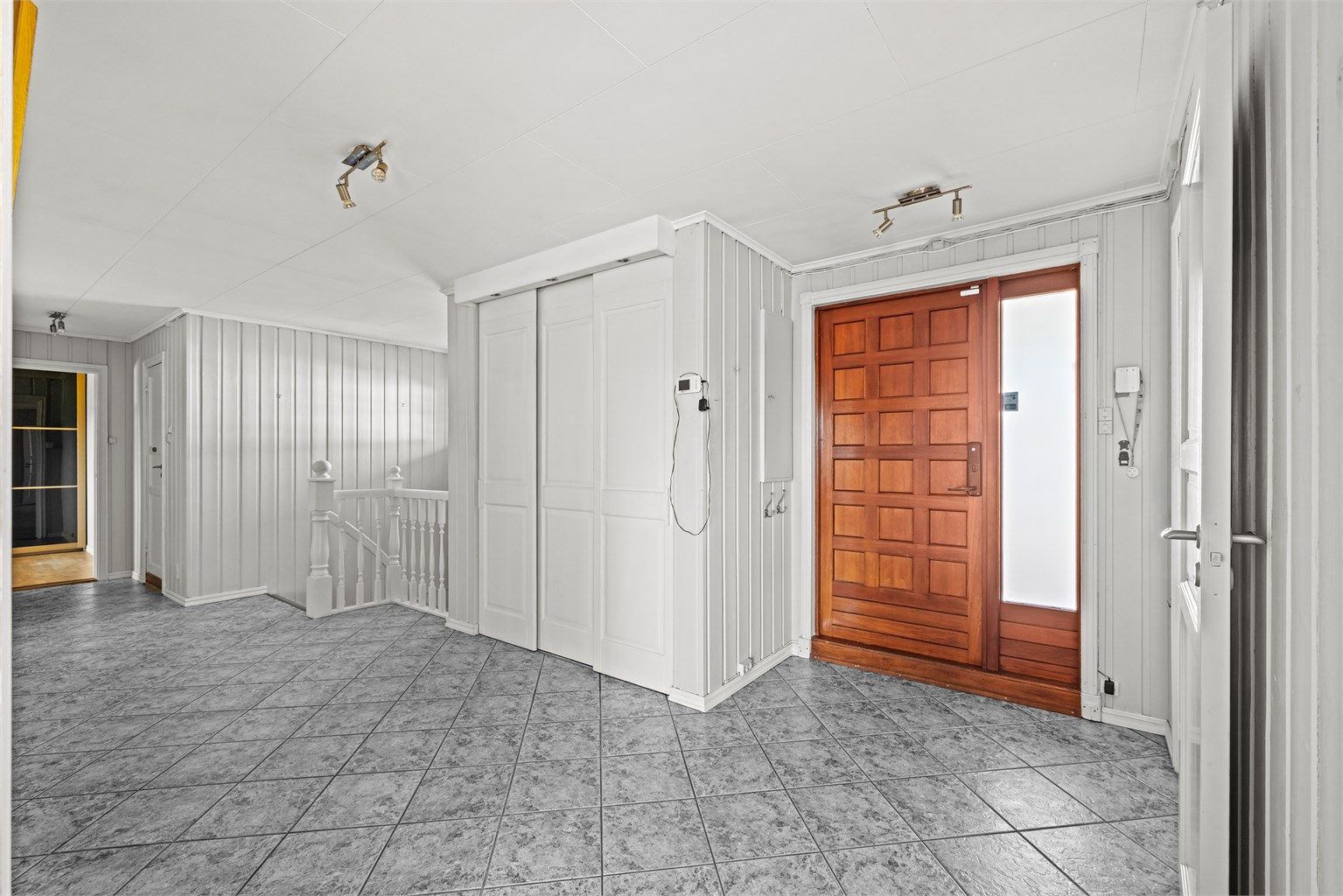 Entréen har flislagt gulv og en stor skyvedørsgarderobe for effektiv oppbevaring.
