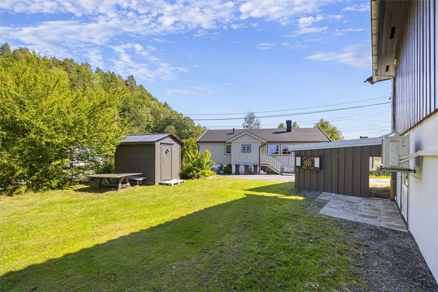 Redskapsbod og inngang til underetasjen fra baksiden.