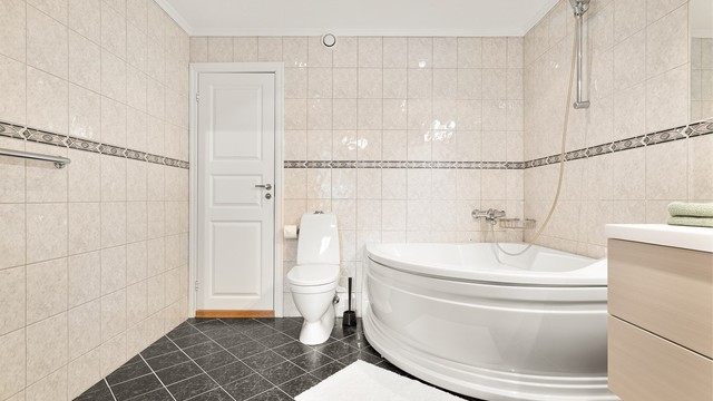 Helfliset baderom med varmekabler i gulv og downlights i himling.