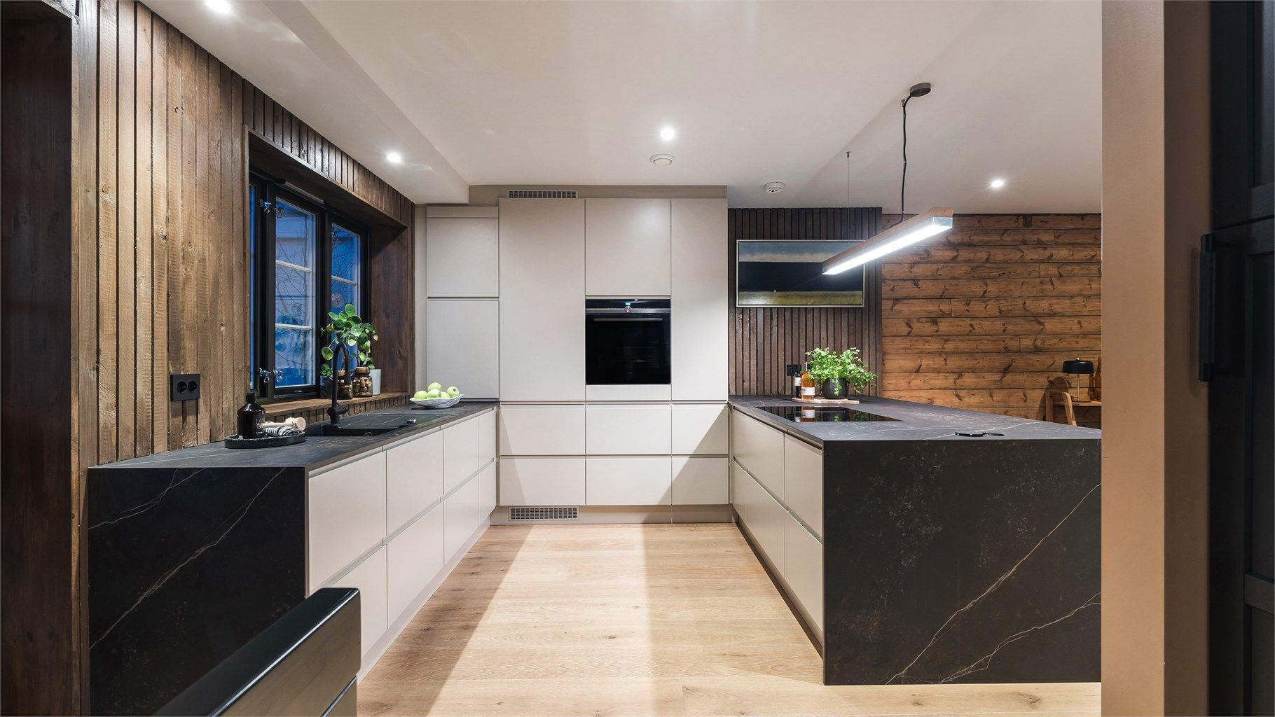 Stilrent kjøkken fra Designa med rikelig med benkeplass og lagring i form av over- og underskap. 