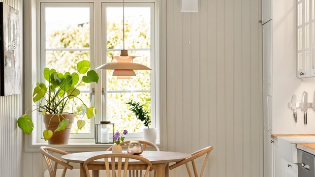 Lysmalte panelplater på vegger og to-fløyede sprossevinduer setter rammene for en klassisk atmosfære.