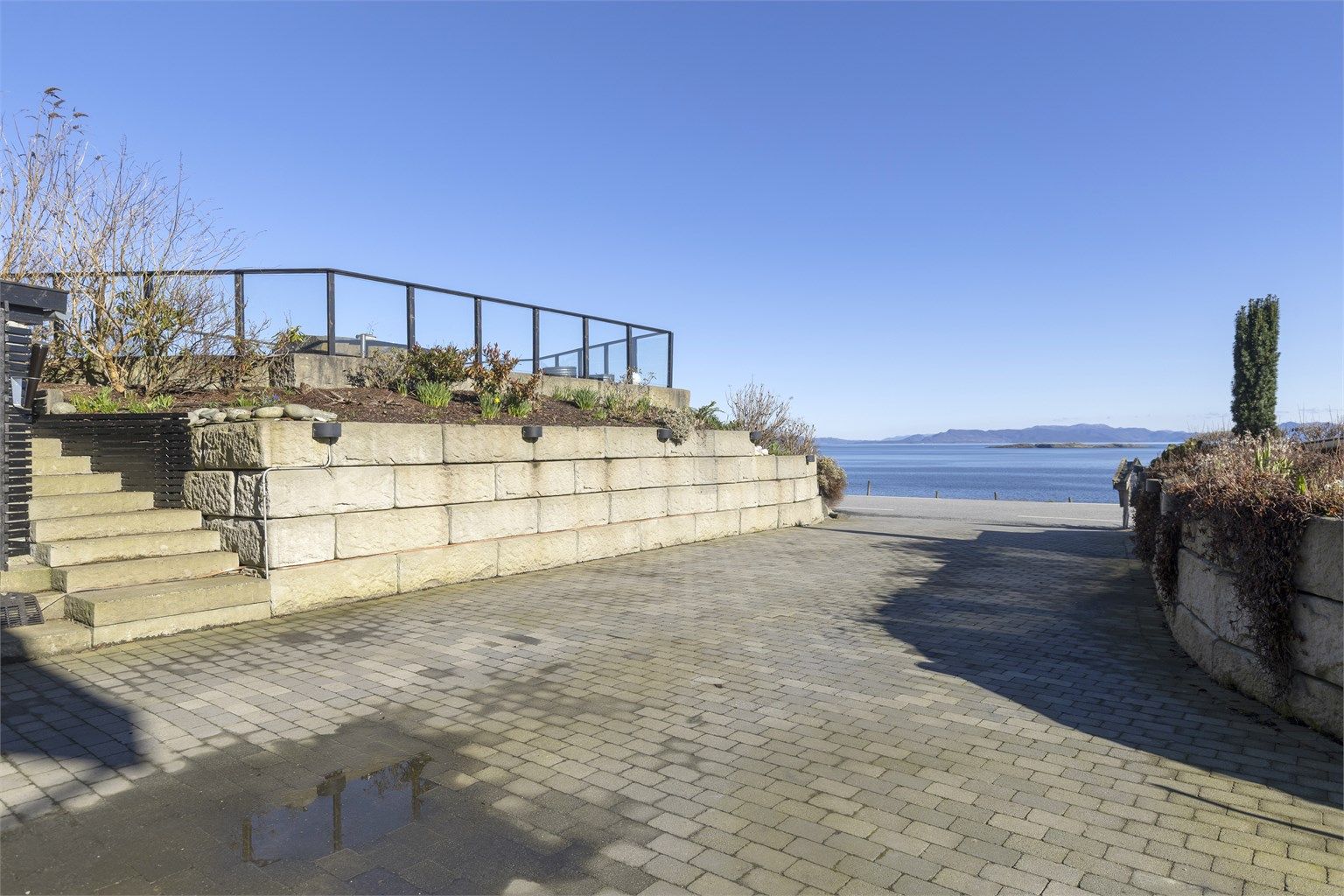 Innkjøringen er pent opparbeidet med belegningsstein og solide forstøtningsmurer i naturstein.