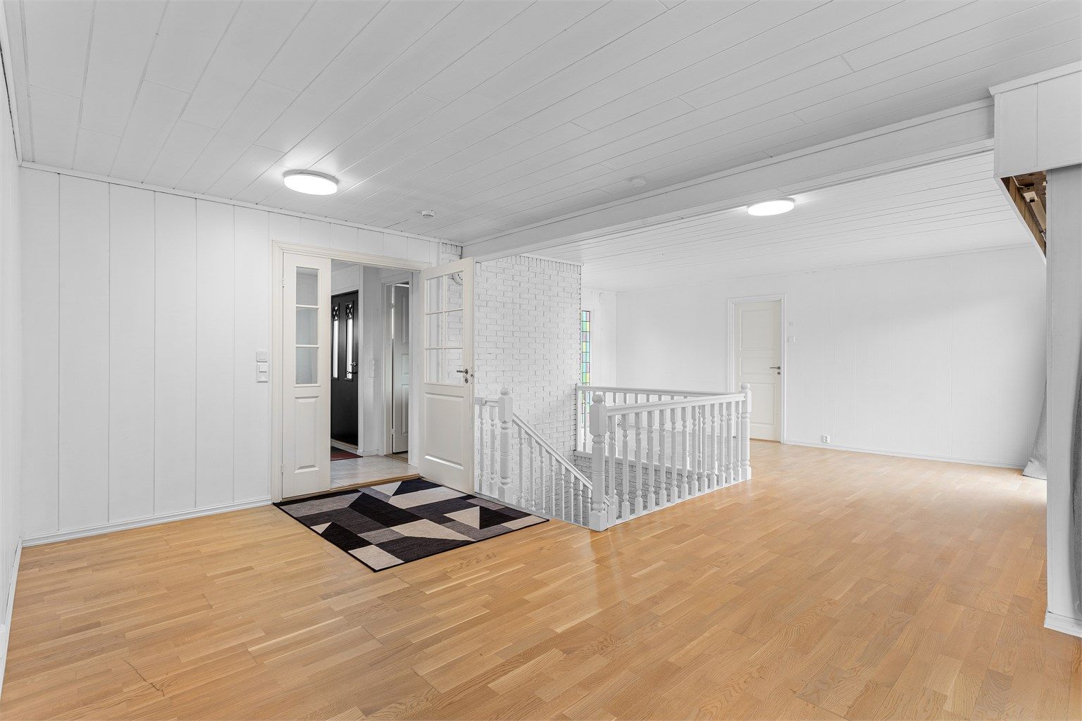 Lys og åpen hall som binder sammen boligens ulike soner i hovedetasjen.