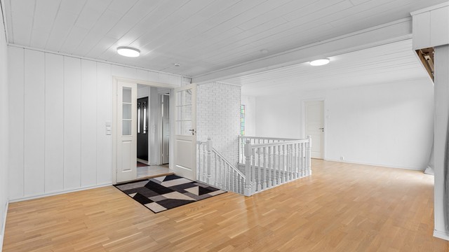 Lys og åpen hall som binder sammen boligens ulike soner i hovedetasjen.