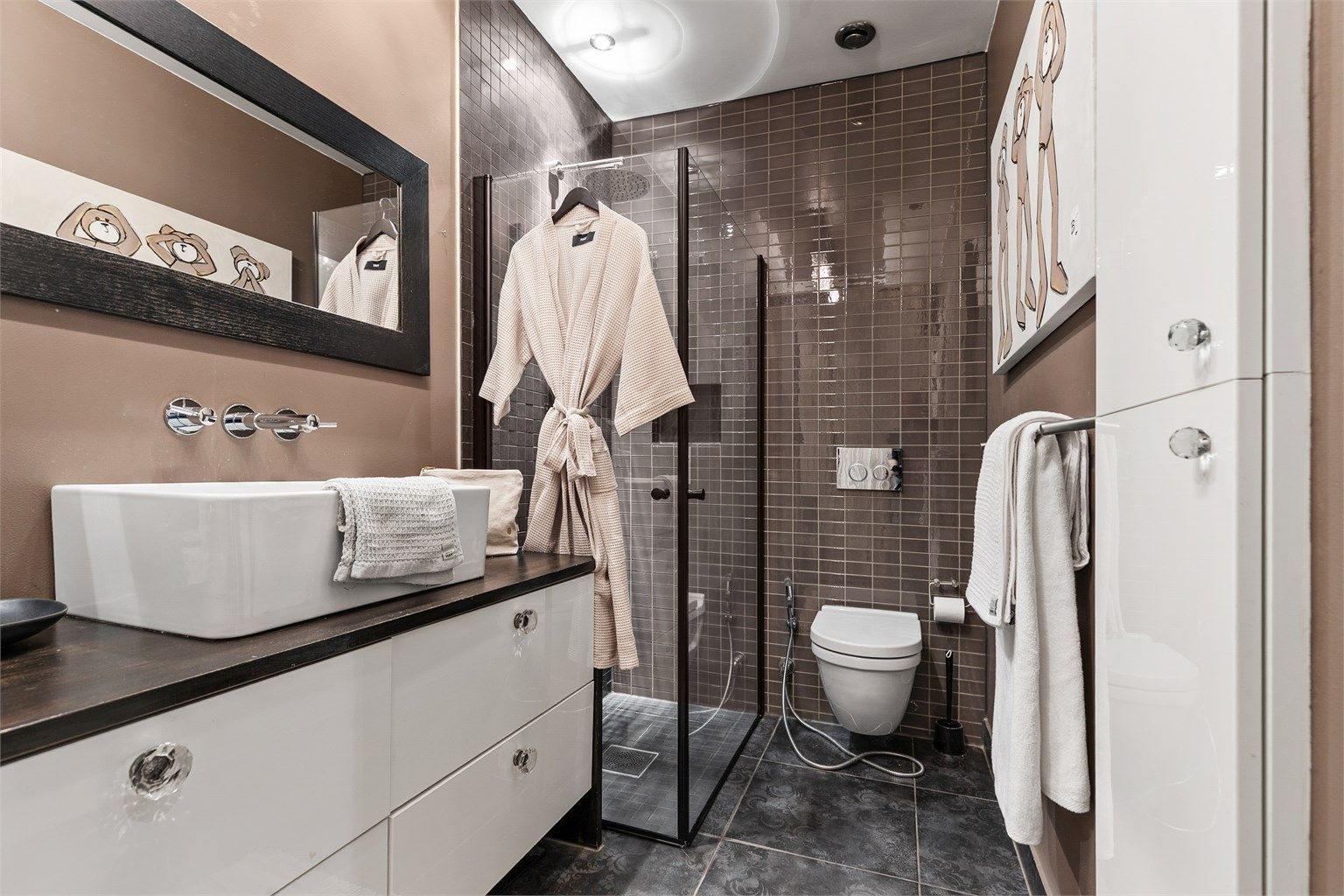 Vegghengt servantinnredning med skuffer. Ovenpåliggende servant med ett-greps armatur. Speil over servant.